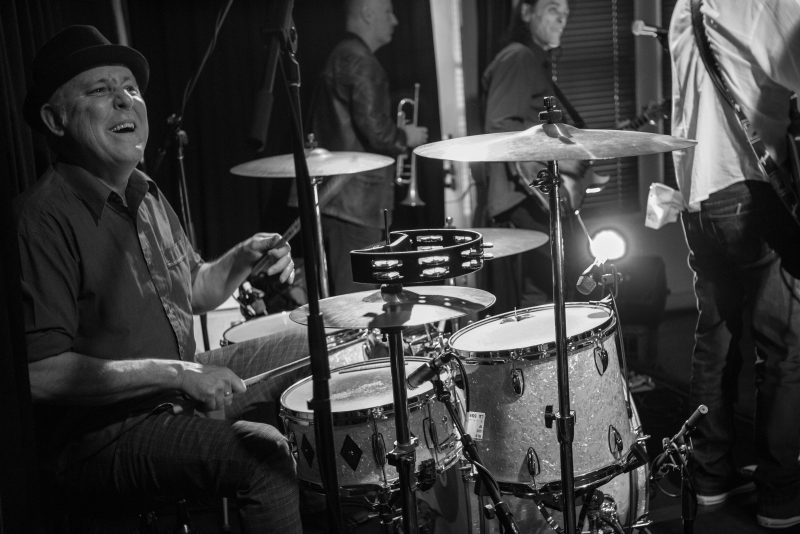 Billy Pommer Jr playing drums and smiling